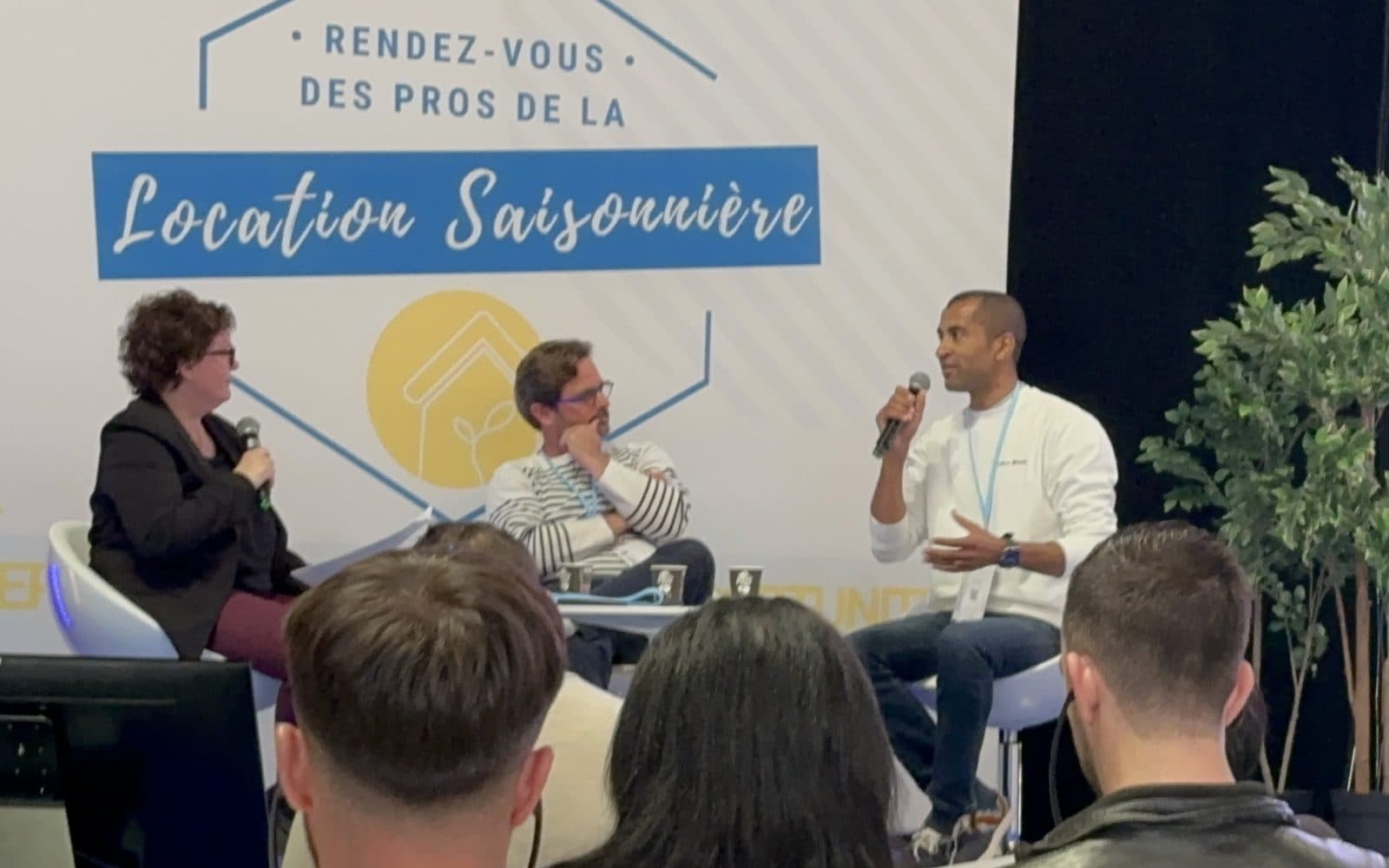 Fred Diaw, micro en main, pendant un panel du Rendez-vous des Pros de la Location Saisonnière, à Paris, devant le panneau du salon